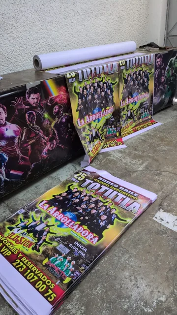 Impresos de gran formato colgados junto a una pila de carteles durante la producción.